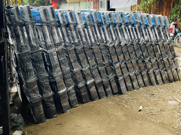 Dãy dài kệ bày ngói gấp gọn bọc màng co xếp dựa nghiêng tại sân xưởng